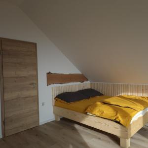 a bed with a yellow comforter in a room at Koča z razgledom in Križe