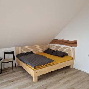 een houten bed in een kamer met een stoel bij Koča z razgledom in Križe