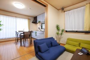 a living room with a blue couch and a kitchen at Lucky Higashi Mizue - Vacation STAY 16180 in Tokyo