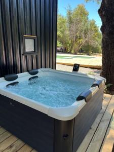 une baignoire jacuzzi assise sur une terrasse en bois dans l'établissement Tiny house en bosque nativo camino a Termas de Chillan, à Recinto