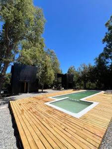 a house on a wooden deck with a golf course at Tiny house en bosque nativo camino a Termas de Chillan in Recinto