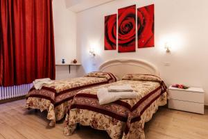 2 camas en una habitación de hotel con cortinas rojas en AI Giardini en Castelnuovo di Val di Cecina