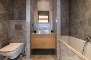 a bathroom with a sink and a toilet and a tub at Résidence Eden - Chalets pour 14 Personnes 124 in Arc 1800