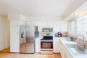 eine Küche mit einem Kühlschrank aus Edelstahl und einer Spüle in der Unterkunft Reno's Radiant Retreat in Reno