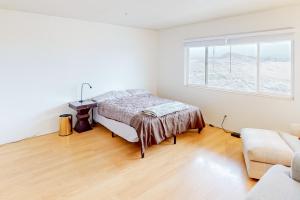 een witte slaapkamer met een bed en een raam bij Reno's Radiant Retreat in Reno
