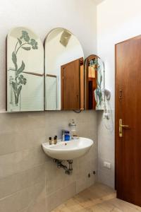 baño con lavabo y 2 espejos en AI Giardini en Castelnuovo di Val di Cecina