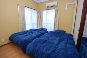 a bed with a blue comforter in a bedroom at Kurokawa Building No, 201 - Vacation STAY 16198 in Nagoya