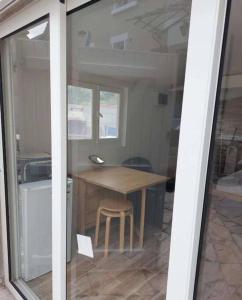 a room with a wooden table and a wooden chair at Brand new studio with garden, easy access to Paris in Sartrouville