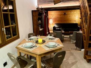 a wooden table with plates and wine glasses on it at Chalet Sarazin - Chalets pour 4 Personnes 994 in Crest-Voland