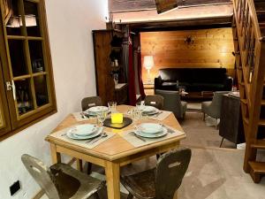 a wooden table with plates and wine glasses on it at Chalets Abbe/tot - Chalet de l'abbé MAE-3994 in Crest-Voland
