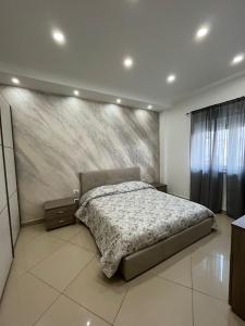 1 dormitorio con 1 cama y una pintura en la pared en Casa vacanza Helios, en Leonforte