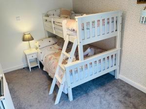 um quarto com 2 beliches e uma cama em Adlington Cottage, Lancashire em Adlington