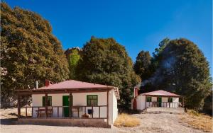 een klein huis in het midden van een veld bij Parque Cueva de los Leones - Rimusa Inn in Creel