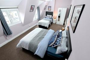 STUNNING 3 Bedroom Serviced Flat IN North London في لندن: غرفة نوم بسريرين ونوافذ