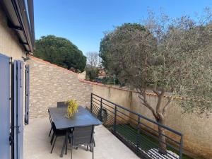 a table and chairs on a balcony with a tree at Maison la londe in La Londe-les-Maures