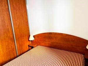 een slaapkamer met een bed met een houten hoofdeinde bij Résidence Pic Du Midi - 2 Pièces pour 4 Personnes 744 in La Mongie