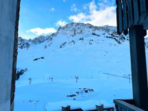 een raam met uitzicht op een met sneeuw bedekte berg bij Résidence Pic Du Midi - 2 Pièces pour 4 Personnes 744 in La Mongie