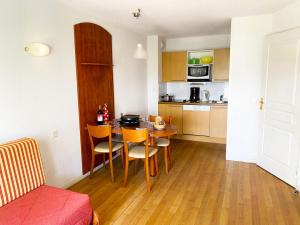 uma pequena cozinha com mesa e cadeiras num quarto em Résidence Pic Du Midi - 2 Pièces pour 4 Personnes 694 em La Mongie