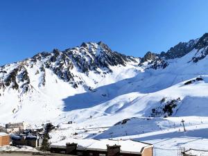 uma montanha coberta de neve com uma cidade em primeiro plano em Résidence Pic Du Midi - 2 Pièces pour 4 Personnes 694 em La Mongie