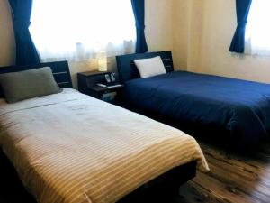 een slaapkamer met 2 bedden en een raam bij Yoron Tandy-House - Vacation STAY 78660v in Yoron