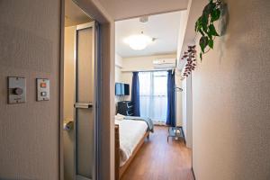 a hotel room with a bed and a window at Tenmabashi Home in Osaka - Vacation STAY 16207 in Osaka