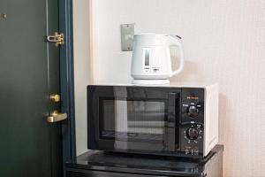 a microwave sitting on top of a table at Tenmabashi Home in Osaka - Vacation STAY 16207 in Osaka