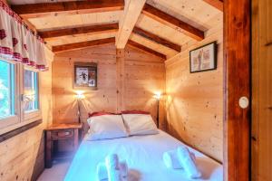 a bedroom with a bed in a wooden cabin at Résidence Les Balluts - 3 Pièces pour 4 Personnes 164 in Morzine