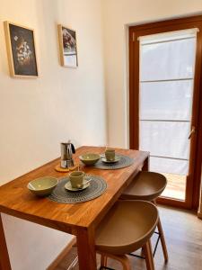 uma mesa de madeira com quatro cadeiras e chávenas em La casa del Mercato em Santa Maria Maggiore