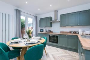 a kitchen with green cabinets and a wooden table and chairs at Rio's Retreat in Cottingham
