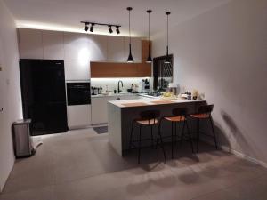 a kitchen with a island with bar stools at חדר מקסים בדירה בה אנו גרים בחולון קרוב לתל אביב וחוף הים כולל מקלט in H̱olon