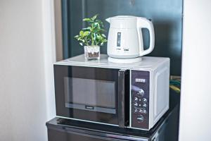 a microwave with a coffee maker on top of it at Tenmabashi Home in Osaka - Vacation STAY 16208 in Osaka