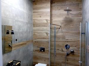 a bathroom with a shower with wooden wall at Dom Bilardowy przy trasie A4 Gliwice Żernica 110m2 