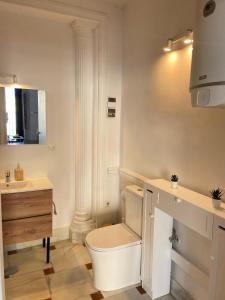 uma casa de banho branca com um WC e um lavatório em Casa Cervantes Malaga em Málaga