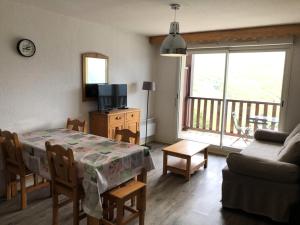 a living room with a table and a couch and a television at Résidence Hauts De Peyragudes Mp - 2 Pièces pour 6 Personnes 844 in Germ