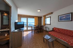 a living room with a couch and a television at Charmant appartement 2 Pièces Cabine 4-6 Personnes in Chamrousse