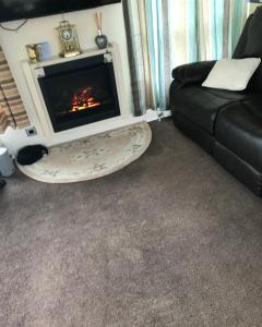 a living room with a fireplace and a couch at 40A Oak Village- 2 Bedroom Lodge on Grange Leisure Park in Mablethorpe