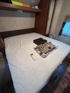 a bed in a room with a white sheet and a cell phone at The Basecamp Yugawara - Vacation STAY 84742v in Miyakami