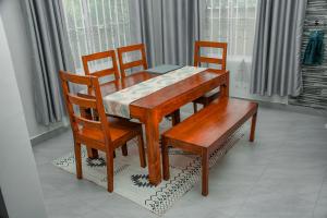 uma mesa de madeira e duas cadeiras e uma mesa e uma mesa e uma mesa em ToLive Homes em Arusha