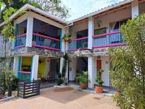 una casa con balconi e piante rosa e blu di Finca Hotel Palma de Iraka - Quindío - Hasta 26 Personas a La Tebaida