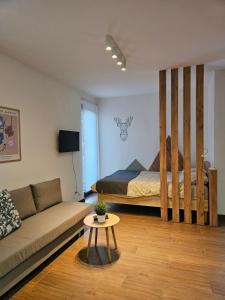uma sala de estar com uma cama e um sofá em Studio Apartman Nomad Divčibare em Divčibare