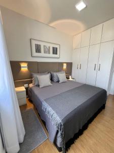 ein Schlafzimmer mit einem großen Bett und weißen Schränken in der Unterkunft Flat Premier 14 Max Savassi in Belo Horizonte