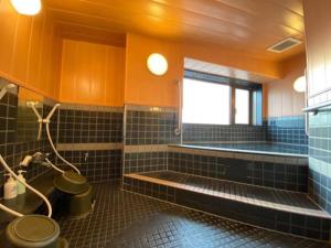 a bathroom with a toilet and a tub and a window at Towada City Hotel - Vacation STAY 85215v in Towada +7 photos
