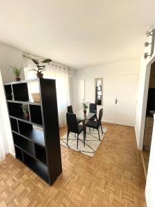 a living room with a table and chairs in a room at Appartement T1 Confort Tête d'Or Doua - Parking Gratuit in Villeurbanne