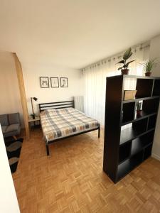a bedroom with a bed and a book shelf at Appartement T1 Confort Tête d'Or Doua - Parking Gratuit in Villeurbanne