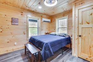 - une chambre avec un lit dans une cabane en bois dans l'établissement Modern Salineville Cabin on 13 Acres with Fire Pit!, 
