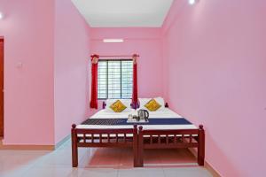 een kamer met een bed en een wastafel bij SPOT ON Greenland Residency in Pathanāmthitta