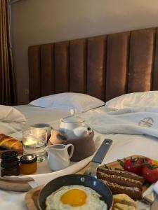 een ontbijtplateau met eieren en brood op een bed bij Grand Hotel Kapan, Armenia in Kapan