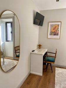 a mirror in a room with a desk and a chair at Casa do Avô Grande in Esposende