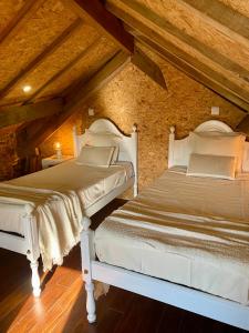 two beds in a attic room with wooden ceilings at Casa do Avô Grande in Esposende