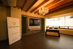 un grand salon avec une télévision et un lustre dans l'établissement Qorianka Hotel, à Lima
